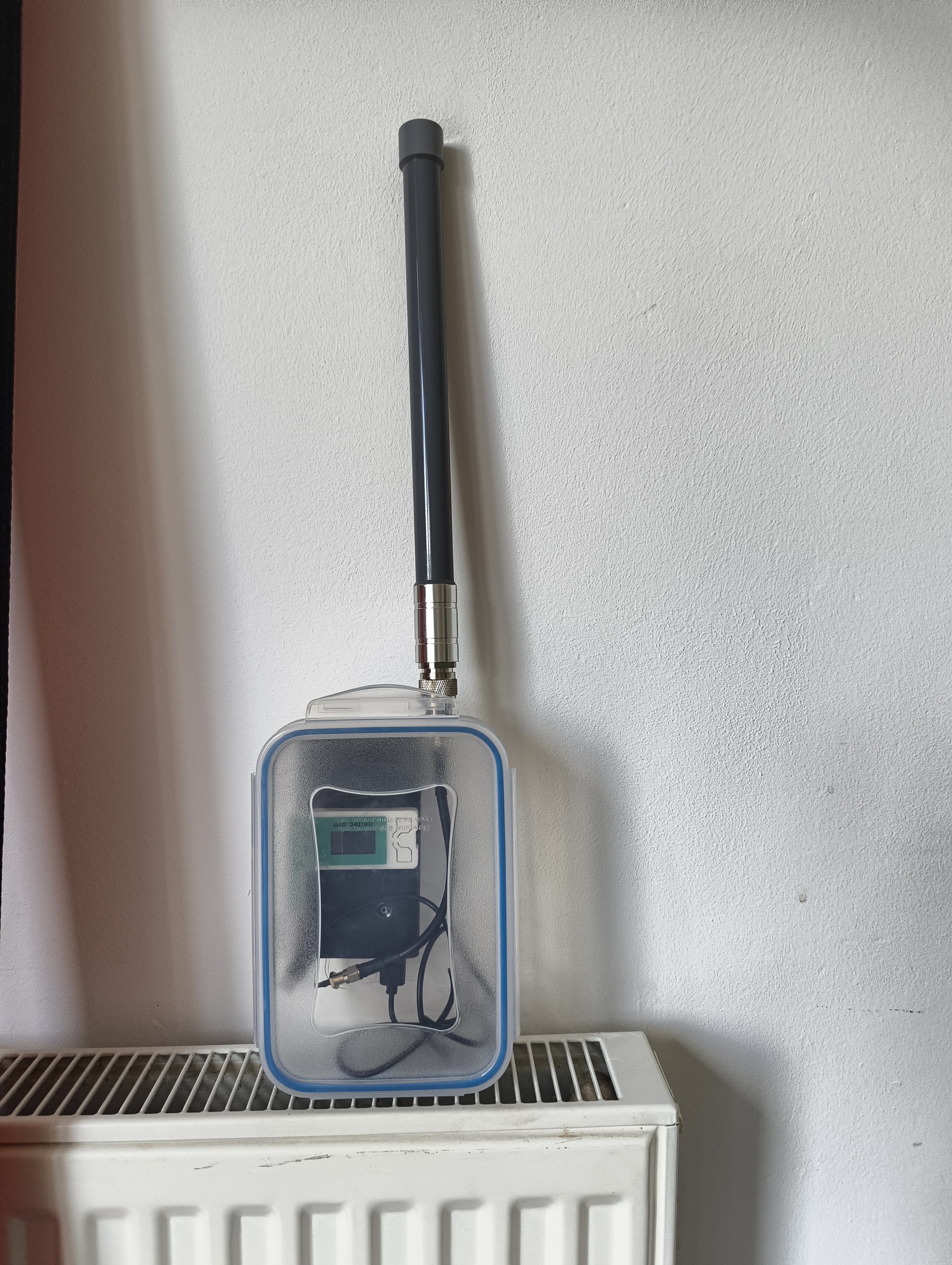 Heltec V3 inside a sealed Tupperware food container with an external 868 MHz antenna through the lid